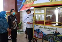 Walikota Prabumulih Ir H Ridho Yahya bersama Ketua PKK Kota Prabumulih Ir Hj Suryanti Ngesti Rahayu Ridho, Wakil Ketua PKK Hj Reni Indayani SKM MSi, Kepala Bank SumselBabel Prabumulih Tian Kedaumpu Yamin ST MM dan Kepala Dinas Perindustrian dan Perdagangan Muhtar Edi SSos menyerahkan bantuan Gerobak Kuliner 25 unit dan Etalase Kuliner sebanyak 100 unit bertempat di pendopo Rumah Dinas Walikota, Rabu (23/12/2020). 