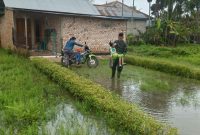 Satgas menggendong sang anak untuk melintasi genangan banjir yang ada di depannya.