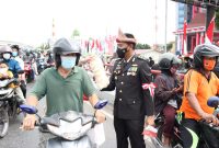 Jajaran Polda Sumsel mengenakan topi adat Palembang (Tanjak) saat detik detik Proklamasi membagikan Telok Abang bagi pengendara yang melintas di depan Mapolda Sumsel