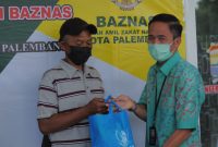 Sekretaris Daerah Kota Palembang Ratu Dewa memberikan secara simbolis bingkisan berupa paket sembako kepada enam orang penggali Kubur.
