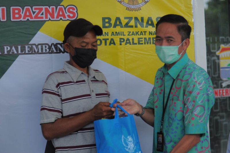 Sekretaris Daerah Kota Palembang Ratu Dewa memberikan secara simbolis bingkisan berupa paket sembako kepada enam orang penggali Kubur.