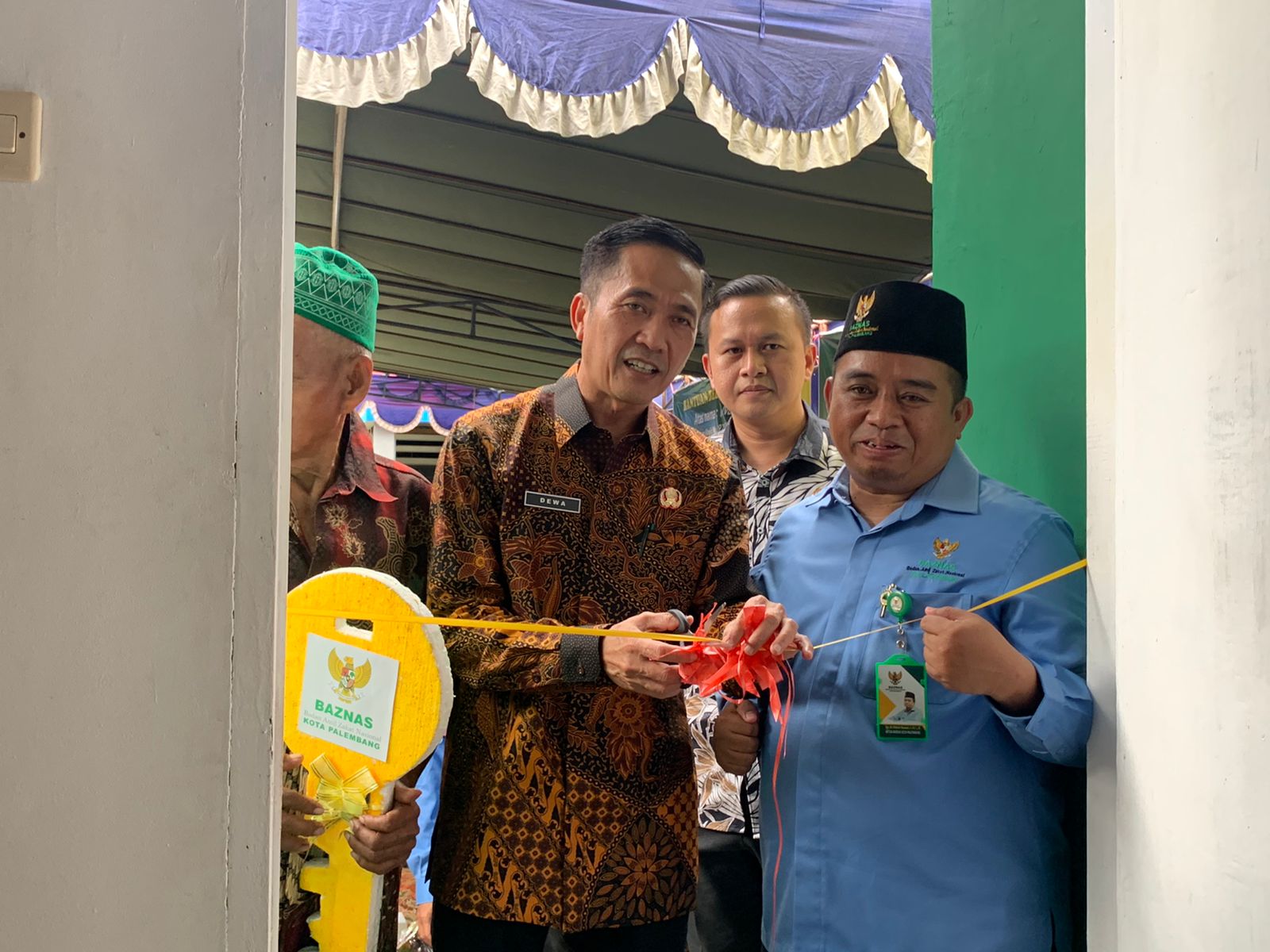 Sekda Kota Palembang Ratu Dewa menggunting pita peresmian rumah M Nur.