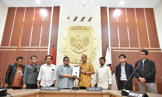 Ketua KPU Hasyim Ashari menyerahkan secara simbolik akun Sistem Informasi Partai Politik (Sipol) kepada Ketua Bawaslu Rahmat Bagja di kantor KPU, Senin, (25/7/2022)