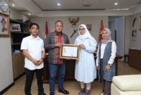Anggota Bawaslu Totok Hariyono memberikan sertifikat sekaligus tanda pengenal pemantau Pemilu 2024 kepada Ketua Netfid Indonesia Dahlia Umar di Kantor Bawaslu