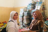 Kepala SMPN 19 Palembang Sri Wahyuni memberikan buku pelajaran baru bagi siswa yang terdampak banjir. 