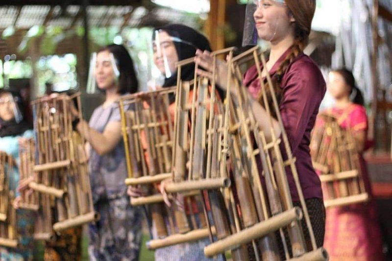 Sejumlah perempuan tengah memainkan alat musik angklung. (Foto: angklung-udjo.co.id)