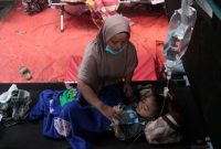 Ridwan Maulana (7) korban gempa bumi Cianjur bersama ibunya Nung Nurmah saat berada di tenda darurat RSUD Sayang, Kabupaten Cianjur, Jawa Barat, Selasa (22/11/2022)