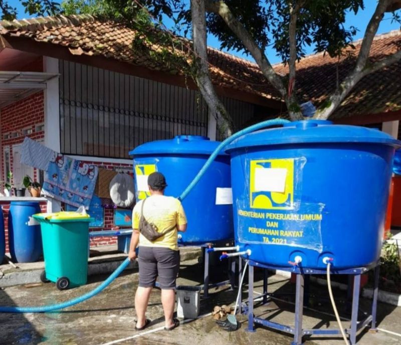Seorang sedang mengisi air bersih untuk masyarakat Cianjur ke dalam tangki penampungan air. Dokumentasi/ PUPR