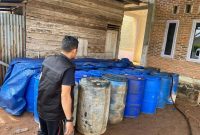 Seorang petugas kepolisian sedang memeriksa timbunan BBM bersubsidi jenis solar di Desa Dayah Baro, Kecamatan Kreung sabee, Kabupaten Aceh Jaya, Kamis (26/1/2023)