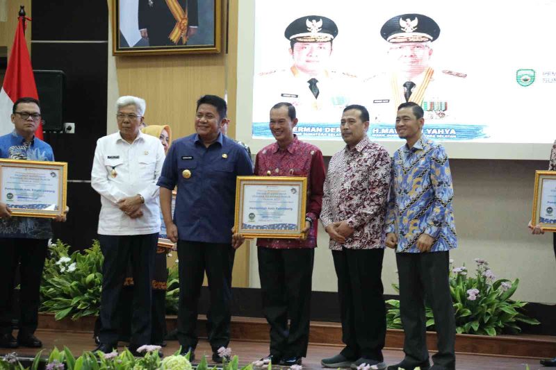 Ketua Ombudsman RI, Mokahammad Najih saat menyerahkan penghargaan kepada Walikota Palembang, H Harnojoyo  di Gedung Bina Praja, Rabu (01/02/2023)