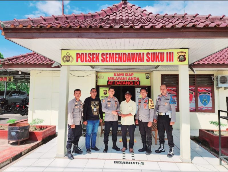 Kepala Desa Taraman, Suhendro saat menyerahkan senpora laras pendek kepada Polsek Kota Semendawai Suku III, Polres OKU Timur