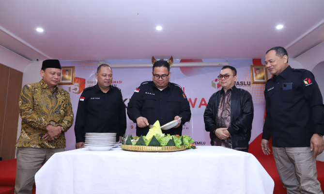 Ketua Bawaslu Rahmat Bagja didampingi Anggota Bawaslu Totok Hariyono memotong tumpeng ada Tasyakuran 15 Tahun Bawaslu, Minggu (9/4/2023).