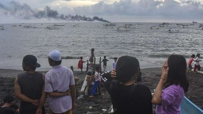 Foto: ilustrasi: Sejumlah warga melihat asap mengepul akibat kebakaran kapal