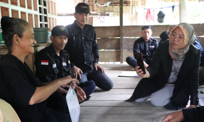 Seorang ibu warga desa Tanah Towa, Kecamatan Kajang, Kabupaten Bulukumba, Provinsi Sulawesi Selatan menunjukkan kartu identitas kepada jajaran pengawas pemilu yang melakukan patroli pengawasan kawal hak pilih