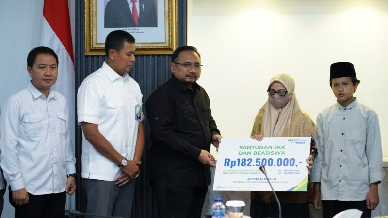 Menag Yaqut Cholil Qoumas menyerahkan secara simbolis klaim Petugas Pembimbing Ibadah Haji tahun 2023 dari BPJS Ketenagakerjaan kepada Khanatus Sa'diah, Selasa (15/8/2023)