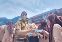 Kepala SMK Negeri 1 Palembang Zulfikri bersama tenaga pendidik membagikan masker kepada peserta didik, Kamis 7 September 2023.