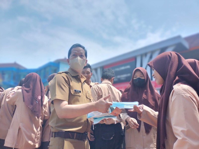 Kepala SMK Negeri 1 Palembang Zulfikri bersama tenaga pendidik membagikan masker kepada peserta didik, Kamis 7 September 2023.