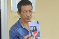 Bambang Irawan menunjukkan foto anak gadisnya TS yang menghilang pasca pamit menginap di rumah temannya