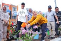 PJ Walikota H Ratu Dewa bersama PJ Ketua PKK Palembang Hj Dewi Ratu Dewa menyirami bunga hias Bougenville di ruas LRT Jalan Angkatan 45 Palembang.