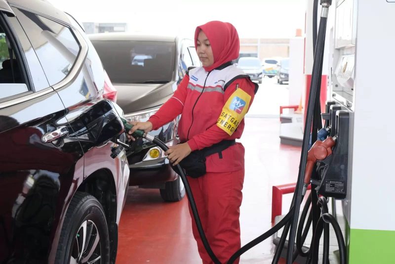 Petugas Pertamina tengah melayani pelanggan mengisi BBM.