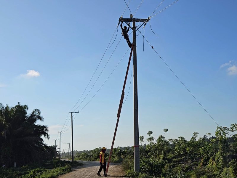 Petugas PLN tengah melakukan pemasangan arus listrik.