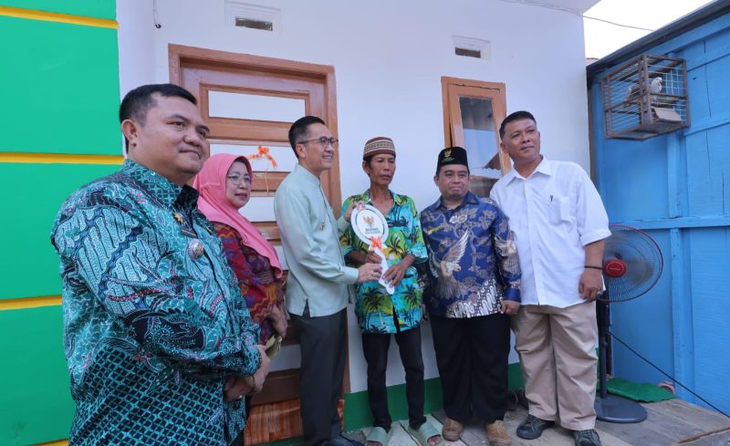 Fauzi tak kuasa menahan tangis haru saat menerima kunci rumah baru secara simbolis yang diserahkan langsung Pj Walikota Palembang Ratu Dewa, Jumat 31 Mei 2024.
