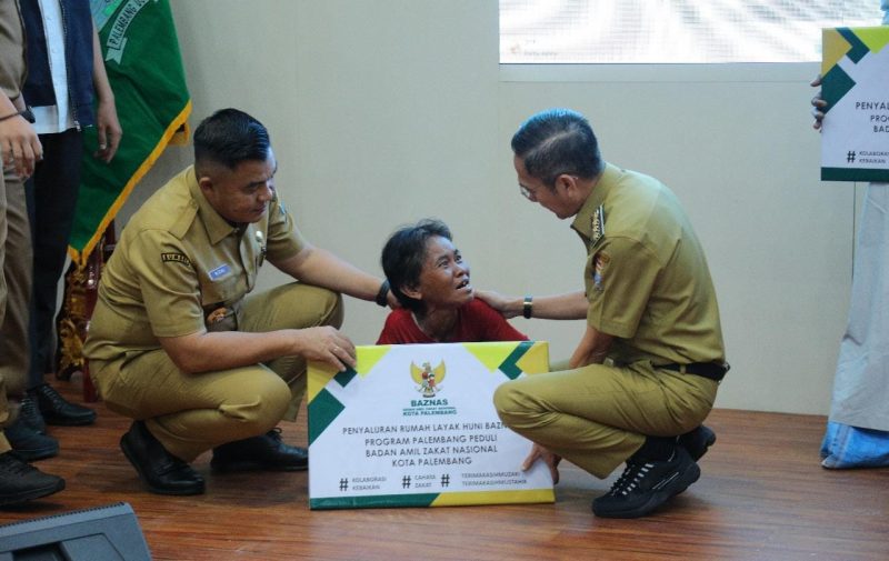 Wali Kota Palembang Ratu Dewa secara simbolis menyerahkan zakat kepada warga kurang mampu.
