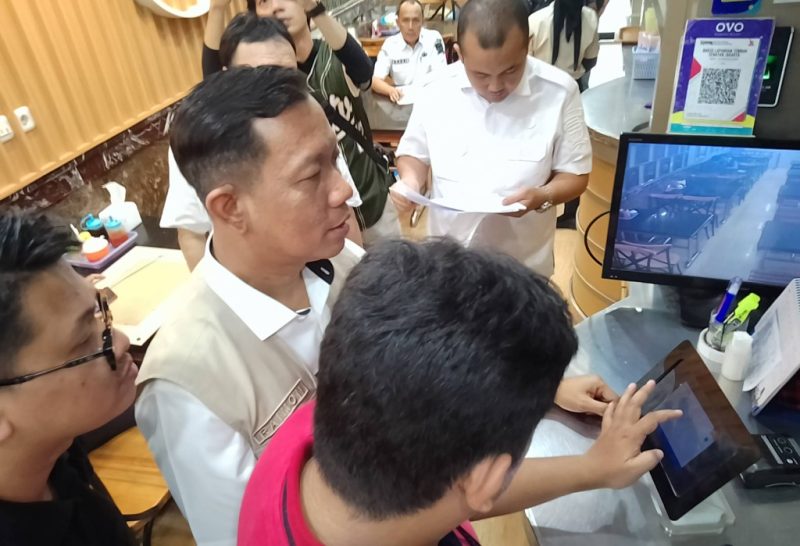 Plt Kepala Bapenda Kota Palembang Raimon Lauri saat mengecek alat perekaman transaksi atau tapping box di salah satu gerai di PS Mall, Rabu 29 April 2026.