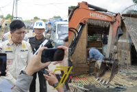 Plt] Sekretaris Sat Pol PP Kota Palembang Budi Ritongga memberikan keterangan di sela perobohan empat pondok liar berukuran mungil, berdiri di Daerah Aliran Sungai [DAS] bersebelahan dengan Pasar Buah Jakabaring.