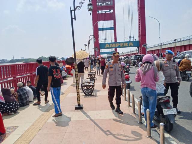 Tampak gabungan personel menertibkan lalu lintas pengendara di sekitar jembatan Ampera.