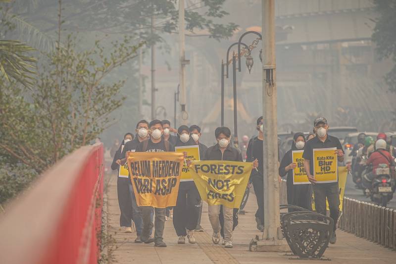 Anak-anak muda anggota Tim Cegah Api Greenpeace Indonesia dan Perkumpulan Rawang di Palembang menyuarakan dampak kabut asap kebakaran hutan dan lahan gambut di sekitar Jembatan Ampera, Palembang, Sumatera Selatan, Rabu, 7 Oktober 2026. [Abriansyah Liberto-WI]