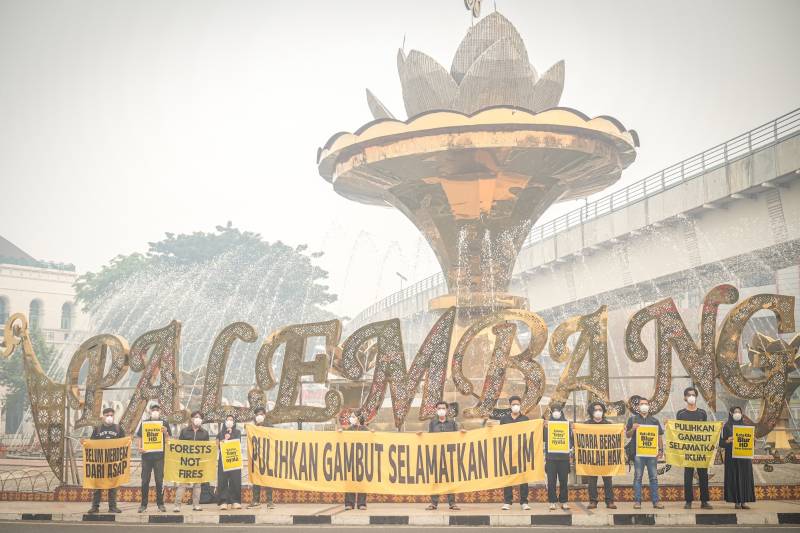 Anak-anak muda anggota Tim Cegah Api Greenpeace Indonesia dan Perkumpulan Rawang di Palembang menyuarakan dampak kabut asap kebakaran hutan dan lahan gambut di sekitar Bundaran Air Mancur, Palembang, Sumatera Selatan, Rabu, 7 Oktober 2026. [Abriansyah Liberto-WI]